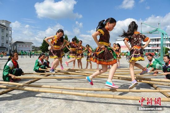 6月16日，貴州省丹寨縣揚武小學學生跳竹排舞。近年來，為了傳承少數民族傳統文化，貴州省丹寨縣積極開展民族民間文化進校園活動。揚武中學以國家級非物質文化遺產錦雞舞、苗族手工蠟染等為基礎自編了錦雞舞大課間體操以及開設了蠟染班、芒筒蘆笙舞班，編寫《苗族蠟染》教材，為少數民族學生搭建了多元化的教育成長平臺。中新社記者